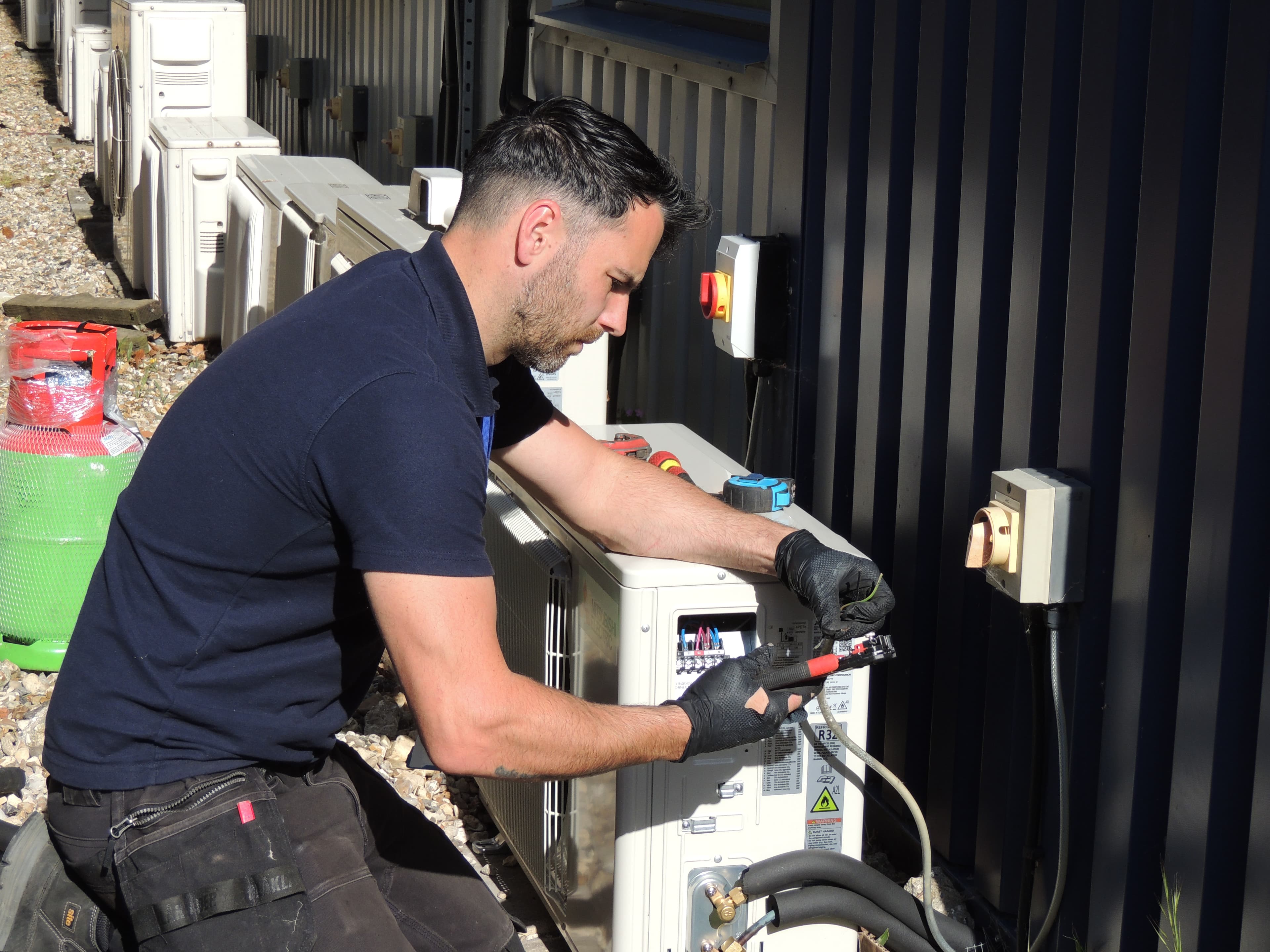 Rossair engineer servicing an external air-source unit
