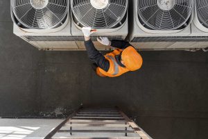 full shot hvac man working with equipment